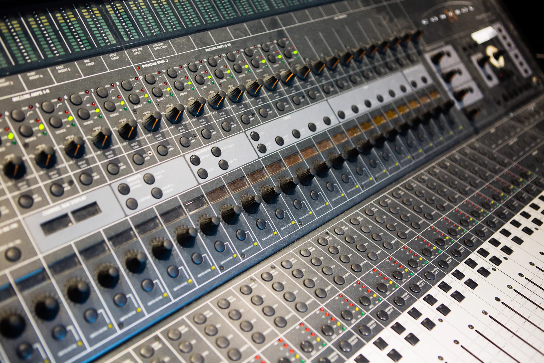 Close-up of a Control 24: mic preamp knobs, encoders, button columns and the fader bank